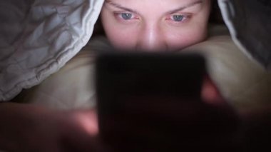 Uykusuzluktan dolayı geceleri telefonu kullanan bir kızın gözlerini gösteren kamera.