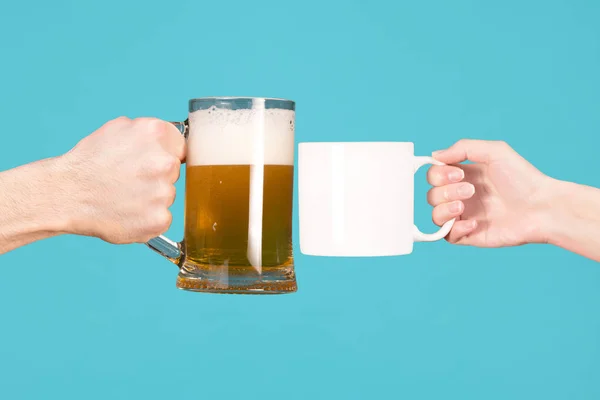 Main masculine et verre avec bière contre la main de la fille avec une tasse de thé ou de café — Photo