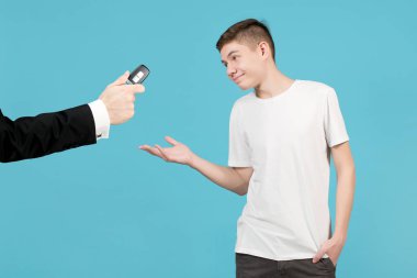 teenager happily accepts a car key, which a man in a jacket holds out to him clipart