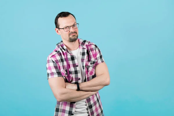 A guy with a beard in a clerical shirt folded his arms over his chest, a dumb question on his face — 스톡 사진