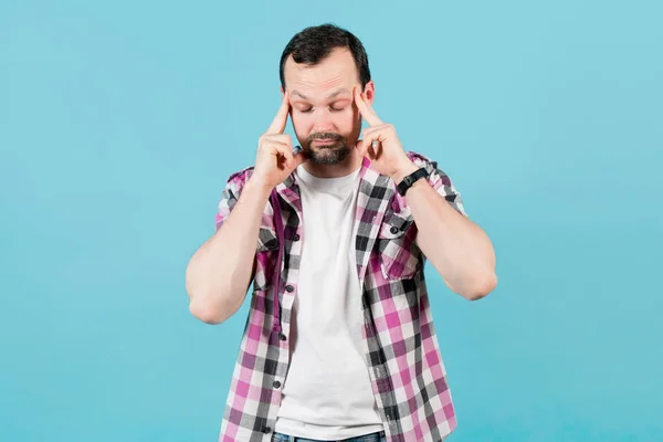 Young man with a bristle in a plaid shirt wrinkles his forehead from fatigue — 스톡 사진