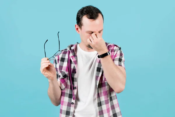 Der Mann nimmt seine Brille ab und knetet die Augenwinkel vor Ermüdung — Stockfoto