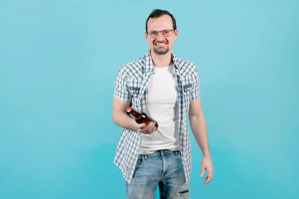 Άντρας με καρό πουκάμισο με τρίχες σε γυαλιά κρατά ένα μπουκάλι μπύρα στο χέρι του — Φωτογραφία Αρχείου