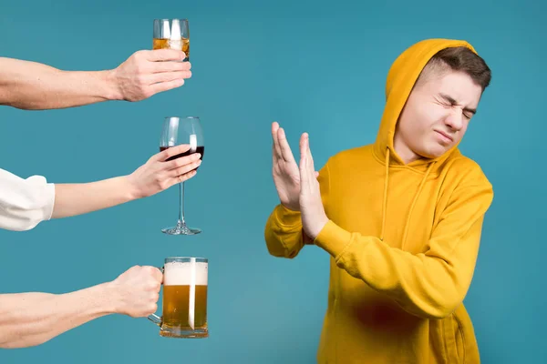 Tiener in een gele sweater weigert verschillende soorten alcohol — Stockfoto