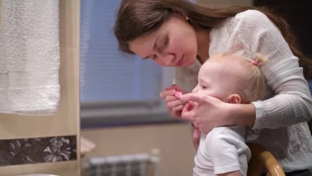 Mãe tenta escovar os dentes do bebê, mas o bebê resiste e não quer — Vídeo de Stock