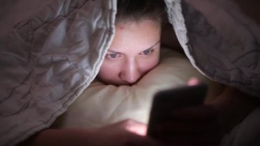 Uykusuzluktan dolayı geceleri telefonu kullanan bir kızın gözlerini gösteren kamera.