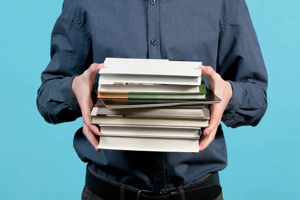 Un montón de libros en manos de un adolescente, entre los que hay una tableta —  Fotos de Stock