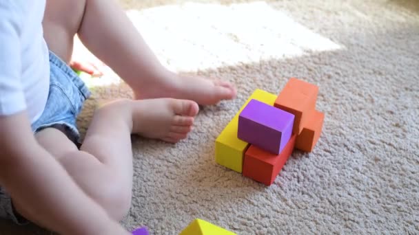 Ein Kleines Mädchen Sitzt Auf Dem Boden Und Baut Bunte — Stockvideo