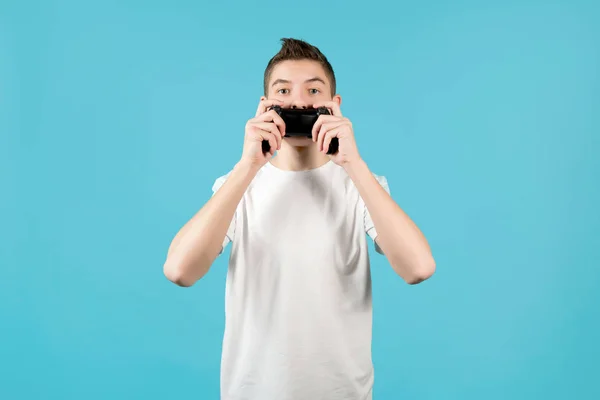 Ein Teenager schließt seinen Mund mit einem Joystick von einer Spielkonsole — Stockfoto