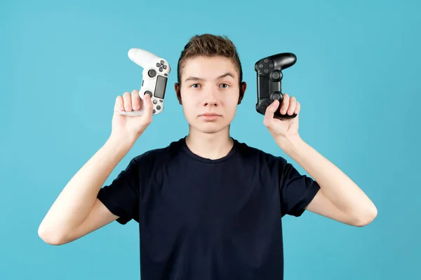 Um adolescente astuciosamente olha para o joystick em sua mão . — Fotografia de Stock