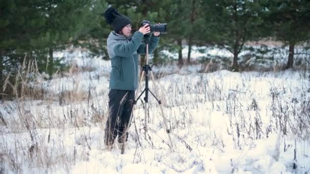 Девушка Энтузиазмом Фотографирует Зимнем Лесу Фотокамеру Которая Стоит Штативе Общий — стоковое видео