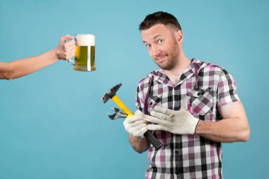 Ellerinde aletlerle pis bir işçi, koruyucu eldivenini elinden alır ve sinsice gülümser çünkü biri elinde bira tutuyor. Sıkı çalışmadan sonra dinlenin