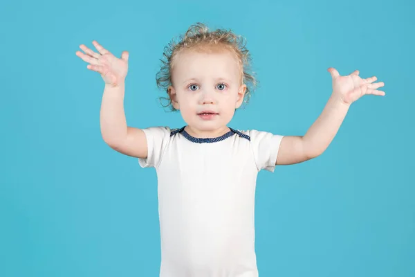 Yıllık Tatlı Kıvırcık Kız Çocuğu Mavi Arka Planda Ellerini Kaldırıyor — Stok fotoğraf