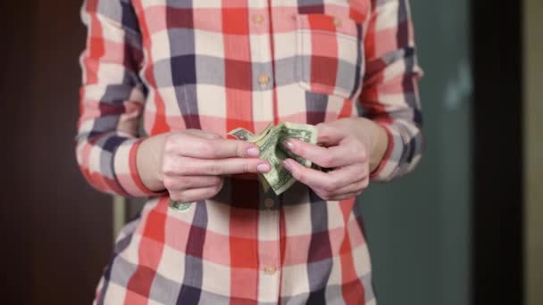 Girl straightens wrinkled dollar bills and folds together — Stock Video