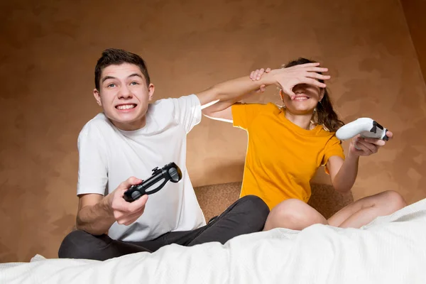 男は女の子がゲームで彼女を倒すために画面を見てから防ぐ — ストック写真