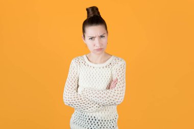 Kız el ele tutuşup kameraya hoşnutsuzca bakıyor. turuncu-sarı üzerinde izole