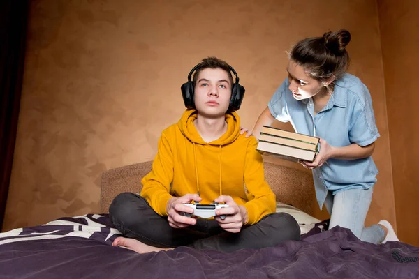 A menina repreende um jovem que é apaixonado por um jogo de computador . — Fotografia de Stock