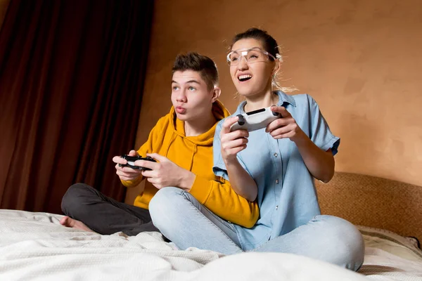 Siostra i brat z entuzjazmem grają w konsolę. — Zdjęcie stockowe