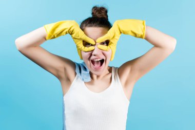 Süper kadın, süper ev kadını. Bir kadın, bir süper kahramanın maskesini parmaklarından çıkarır. Ev eldivenli kız. Mavi üzerine izole edilmiş.