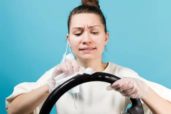 Κορίτσι Απολυμαίνει Προσεκτικά Τιμόνι Απομονωμένα Μπλε Φόντο — Φωτογραφία Αρχείου