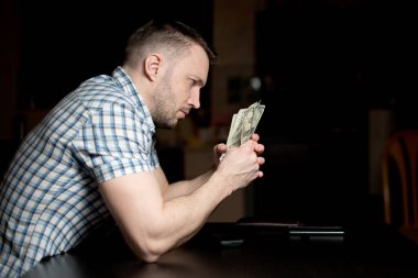 Genç üzgün bir adam akşam geç saatlerde mütevazı tasarrufları düşünür. Zor zamanlar, kriz