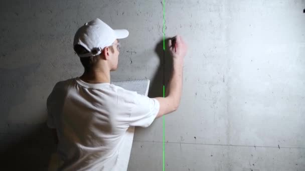 O mestre faz esboços de cálculos em uma parede de concreto durante a construção — Vídeo de Stock