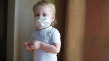 Koruyucu tıbbi maskeli kız üzgün ve pencerenin yanında ağlıyor.