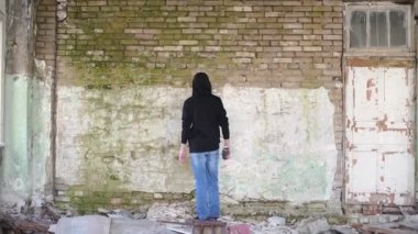 Bir genç, duvarlara sprey boyayla resim yapıyor.