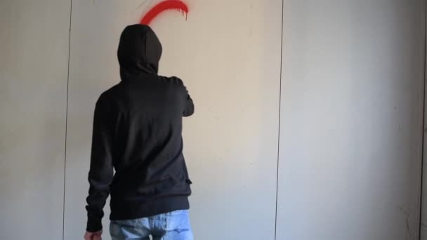 Guy inscribes spray paint on a clean wall in an abandoned building — Stock Video