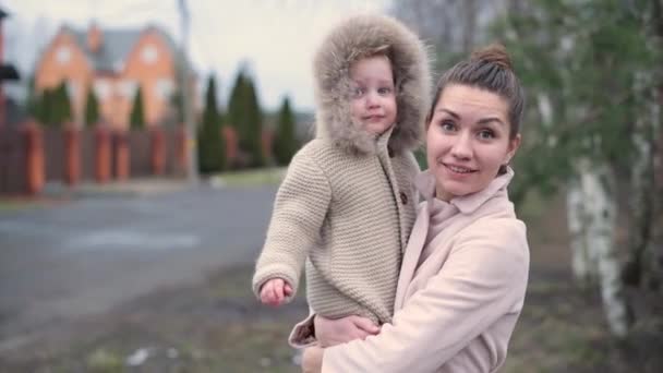 Porträt einer lächelnden Mutter mit kleiner Tochter an einem kühlen Herbstabend — Stockvideo