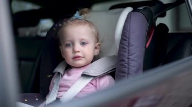 Araba koltuğundaki küçük kız. Pencere kapanıyor ve araba ayrılıyor.