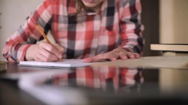 Jovem estudante faz anotações em um caderno, close-up — Vídeo de Stock