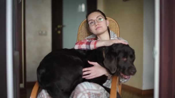 Een Meisje Een Schommelstoel Zit Met Een Grote Hond Schoot — Stockvideo