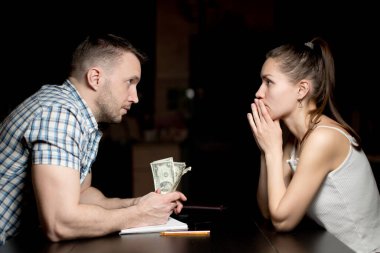 Bir adam ve bir kadın gecenin geç saatlerinde birbirlerine bakıyorlar. Birikimlerini ellerinde tutan bir adam. Ailedeki mali kriz.