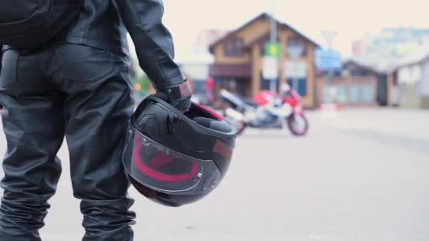 Een Motorrijder Leren Broek Met Een Helm Zijn Handen Gaat — Stockvideo