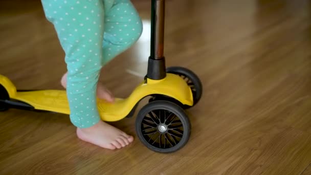 Un petit enfant commence à se déplacer sur un scooter dans le couloir de la maison — Video