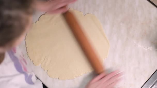 Дівчина катає тісто на столі з прокатним штифтом — стокове відео