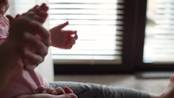 Mains de maman et petite fille qui jouent ensemble près de la fenêtre — Video