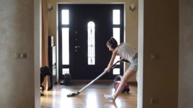 Mutlu kız elinde elektrikli süpürgeyle koridora uçar ve dans ederek temizliğe başlar.