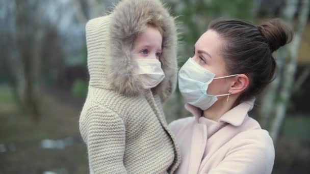 Máma Malou Dcerou Náručí Obě Lékařských Maskách Chladného Večera Ulici — Stock video