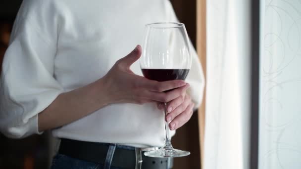 少女はワインを手にグラスを持って酒を飲む ガラスで手を閉じる — ストック動画