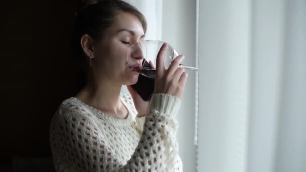 아침에 근처에서 전화를 와인을 마시는 여자의 모습을 클로즈업 — 비디오