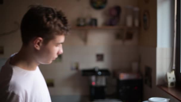 睡梦中的青少年早上来到厨房的水槽边 从一个塑料罐子里喝水 — 图库视频影像