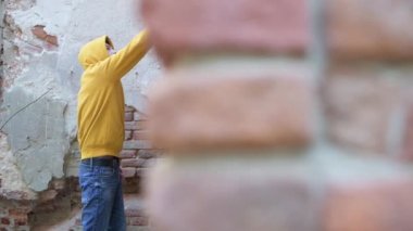 Duvarı boya kutusuyla boyayan bir gencin köşesinden bir manzara.