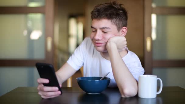 Adolescente Sta Messaggiando Uno Smartphone Piatto Porridge Durante Colazione — Video Stock