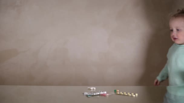 Ένα Κοριτσάκι Βρίσκει Χάπια Στο Τραπέζι Και Παίζει Μαζί Τους — Αρχείο Βίντεο