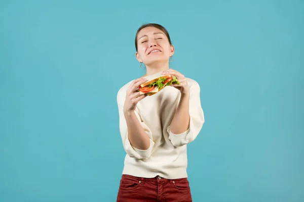 Een Jonge Vrouw Lijdt Houdt Een Broodje Haar Handen — Stockfoto