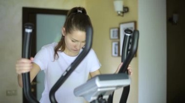 Kız elipsoide gider, programı başlatır, çalışmaya başlar ve onu bitirir. Spor ve spor aletleri evde.