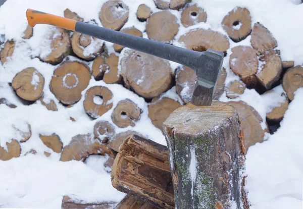 Hacha en tronco de leña almacenada en invierno Fotos de stock
