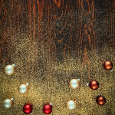 Düz bir ahşap zeminde parıldayan küçük mücevherler. Işıldayan, pırıl pırıl kışın Noel arkaplanı. Reklam ürünleri, dekorasyonlar ve metin için yer.